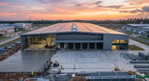 Modern industrial smart warehouse construction featuring sustainable solar roof trusses and precise concrete floor installation in Indonesia.